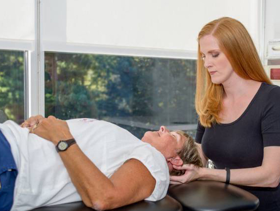 Point Performance therapist Sara Davis examines a patient for neck and back pain