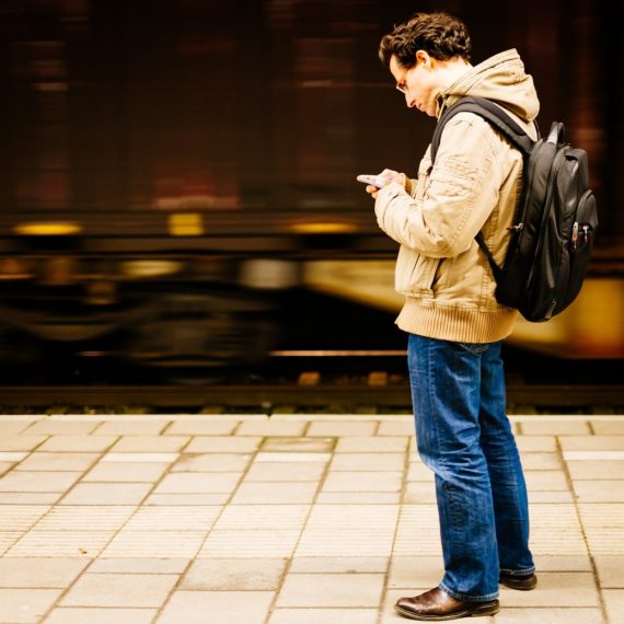 Man getting neck pain from looking down at smartphone