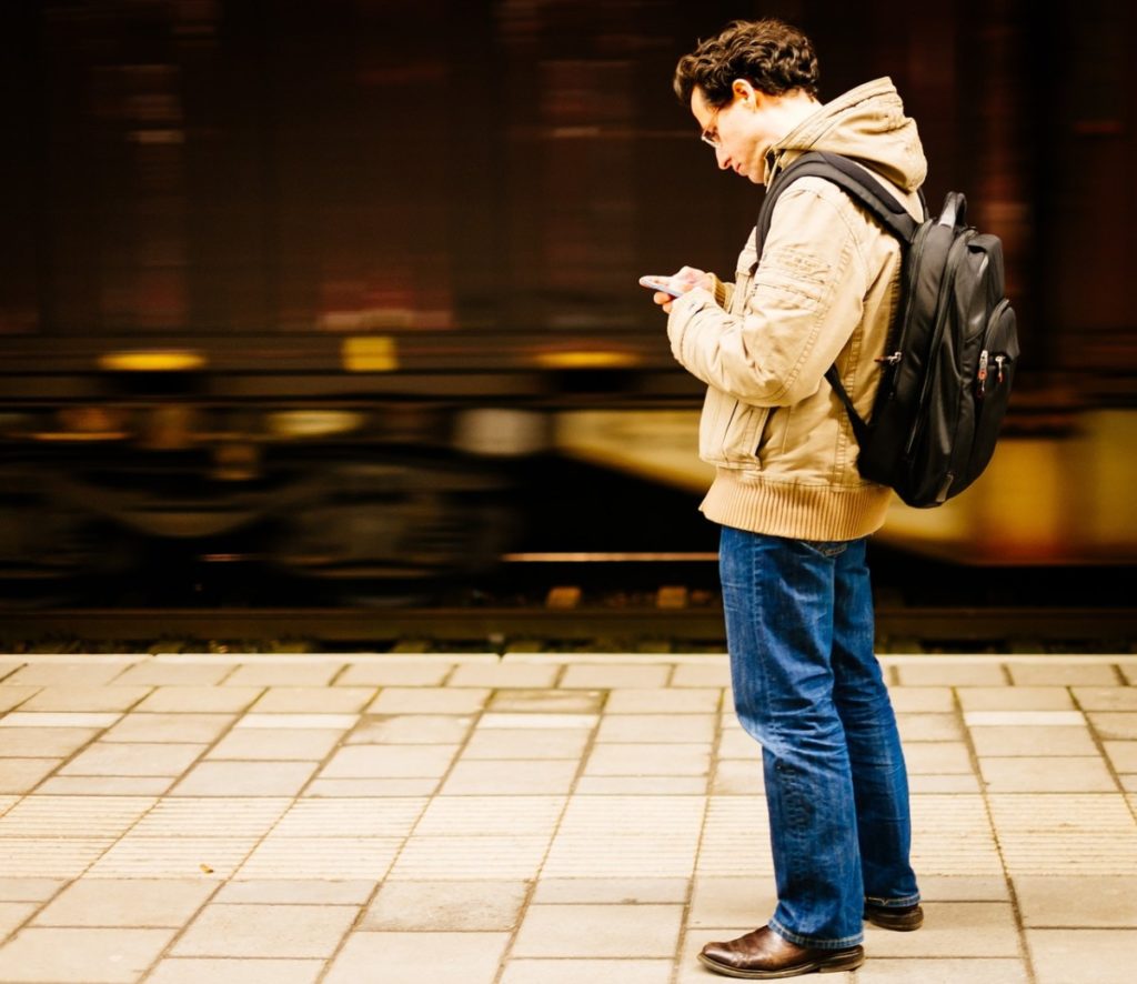 Man getting neck pain from looking down at smartphone