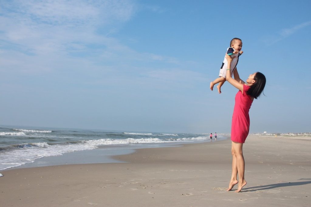 mother tossing baby in air