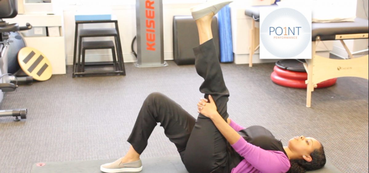 Physical therapist demonstrates hamstring stretch on floor